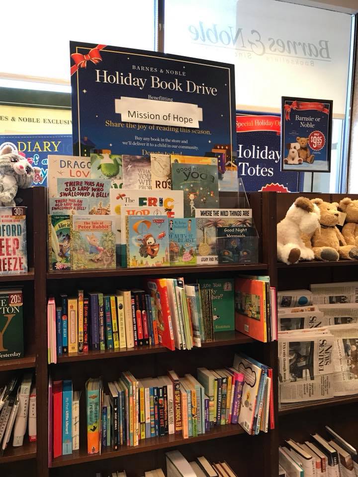 A teddy bear is on display in a book store.