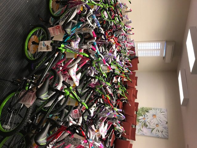 Many bicycles are lined up in a room.