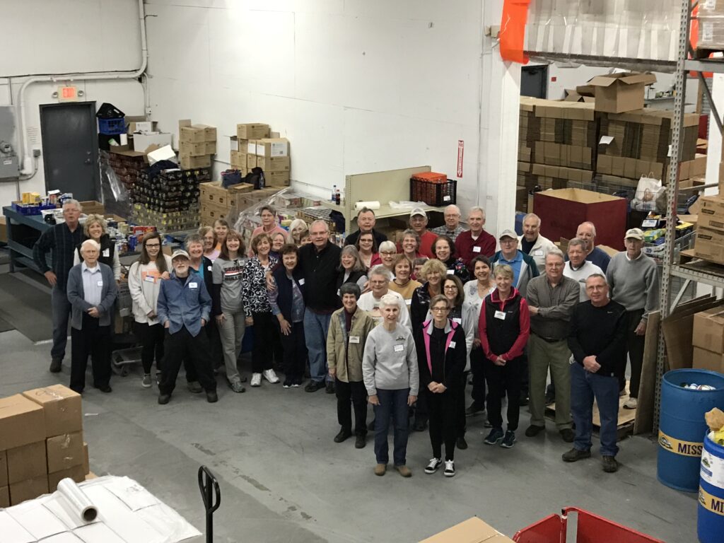 A group of people standing in a warehouse.