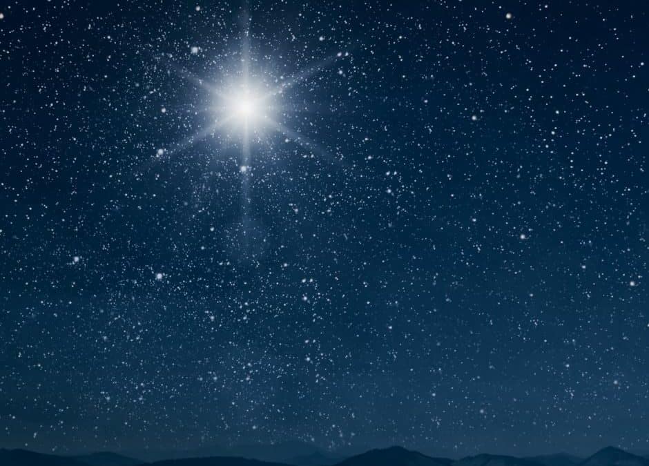 A star is shining in the sky above a mountain.