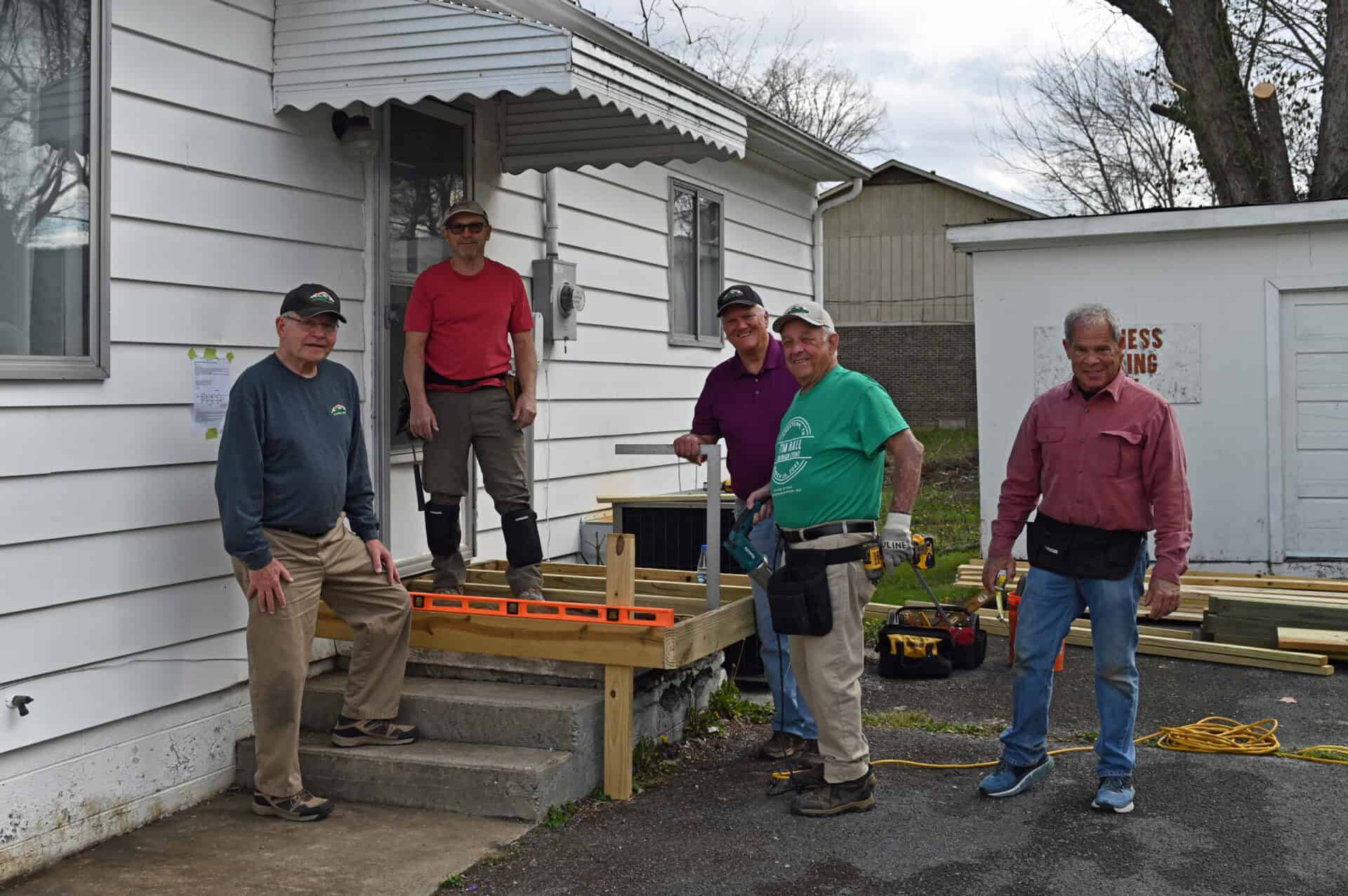 A group of men standing on the steps of a house.