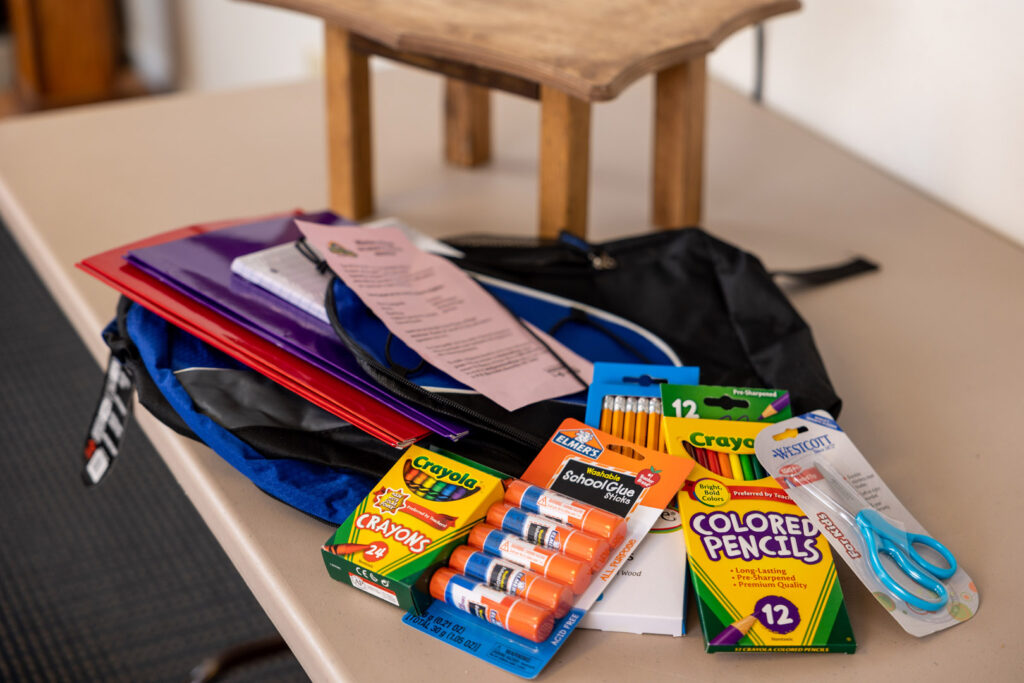 A backpack filled with school supplies on a table.