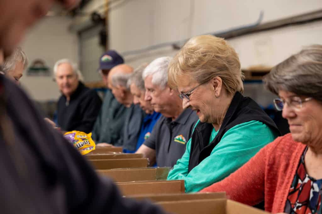 A group of older people standing in a warehouse.