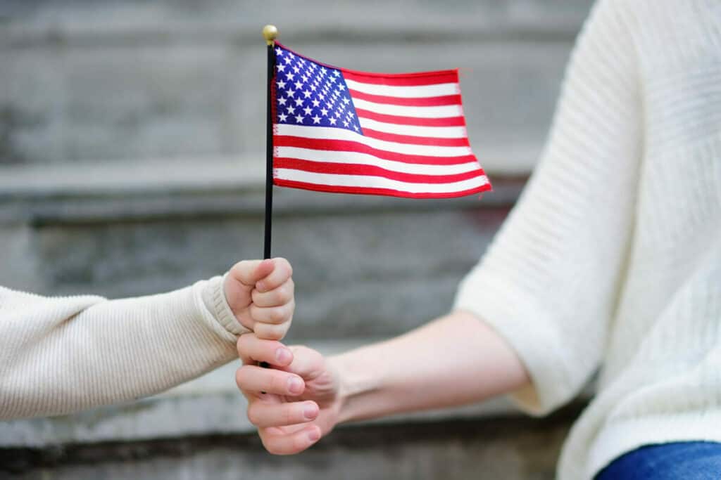 A woman holding an american flag in her hand.